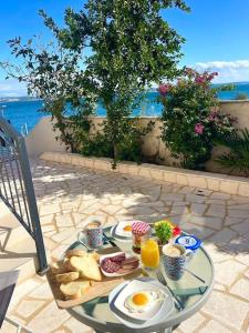 a table with eggs and bread and drinks on a patio at Villa Ocean View of Kali - Erste Meerreihe mit Pool in Kali