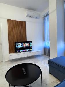 a living room with a tv and a black table at Prime Luxury Apartments in Lushnjë