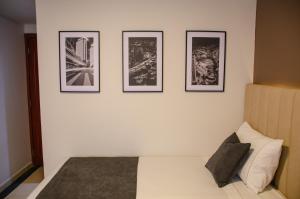 4 fotografías enmarcadas en una pared sobre una cama en Hotel ByHours Las Américas en Bogotá