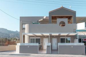 a white house with a fence in front of it at Harmony Luxury 2 in Ierápetra