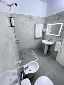 a white bathroom with a sink and a toilet at Prime Luxury Apartments in Lushnjë