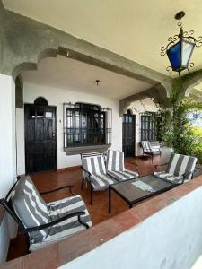 a patio with chairs and a glass table and a table at Mikaso Hotel in San Pedro La Laguna