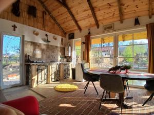 a kitchen with a table and chairs in a room at Mica fermă veselă in Câmpulung Moldovenesc +80 photos