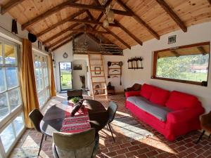 a living room with a red couch and a table at Mica fermă veselă in Câmpulung Moldovenesc