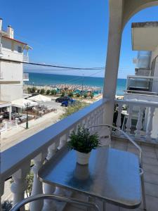 a table on a balcony with a view of the beach at Korali Hotel in Paralia Katerinis