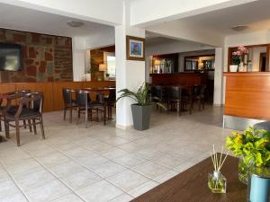 a restaurant with chairs and tables and a bar at Korali Hotel in Paralia Katerinis