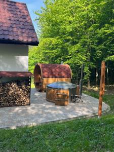 a patio with a table and a wooden structure at Domek w lesie Sauna i Gorąca balia Wellness&Spa in Grybów