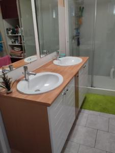 a bathroom with two sinks and a shower at location pour 24h du mans in Arnage