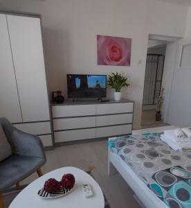 a living room with a bed and a tv at Studio M in Pula