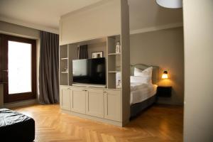 ein Schlafzimmer mit Bett und Flachbildfernseher in der Unterkunft Mimosa Hotel in Westerland