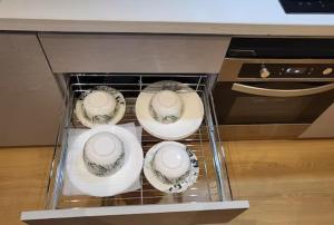 a drawer with four plates and bowls in it at GT Stay Studio 1802 in Ghaziabad