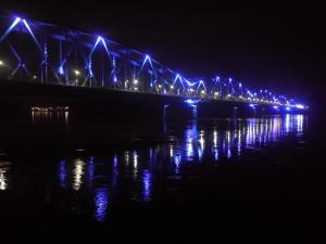 een brug met blauwe lichten op het water in de nacht bij Apartament jacuzzi na toruńskiej starówce in Toruń