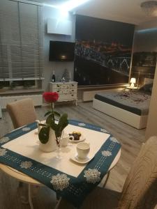 Una sala de estar con una mesa y una cama. en Apartament jacuzzi na toruńskiej starówce, en Toruń
