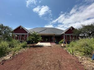 una grande casa con un cortile davanti di Manyara Exclusive Safari Lodge a Mto wa Mbu
