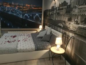 Un dormitorio con una cama y dos mesas y dos lámparas. en Apartament jacuzzi na toruńskiej starówce, en Toruń
