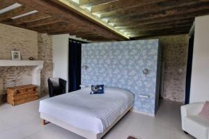 Schlafzimmer mit einem Bett mit blauer Wand in der Unterkunft Charmante maison au coeur du Limousin - Comme à la maison in Lussac-les-Églises