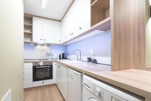 a kitchen with white cabinets and a wooden counter top at No125 - City Centre Studio Apartment in Orestiada