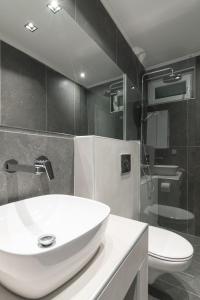 a bathroom with a white sink and a toilet at No125 - City Centre Studio Apartment in Orestiada