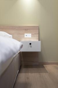 a bed with a white night stand next to a bed sidx sidx sidx at No125 - City Centre Studio Apartment in Orestiada