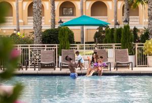 una familia sentada en la piscina de un complejo en The Ritz-Carlton, Sarasota, en Sarasota