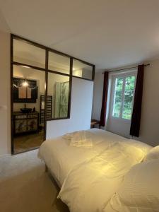 1 dormitorio con 1 cama grande y espejo grande en La Maison Voyage Bed and Breakfast, en Onzain