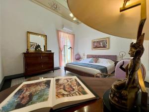 Un dormitorio con una cama y una mesa con un libro en Palazzo d'Autore - Luxury Home - Ragusa Centro en Ragusa