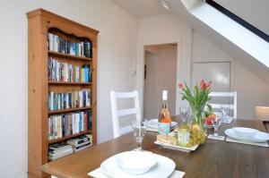 a dining room with a table and a book shelf at Heronlea Cottage in Dunoon