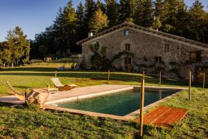 una piscina frente a una casa de piedra en La Paradella - Apartamento de uso turístico, en Arbúcies