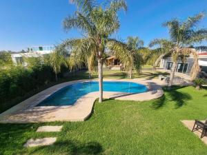 una piscina en un patio con una palmera en Fes Villa with Pool - Serene Oasis Retreat - Fez en Aïn Smar