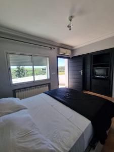 1 dormitorio con 1 cama grande y 2 ventanas en Fes Villa with Pool - Serene Oasis Retreat - Fez en Aïn Smar