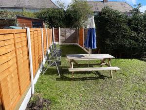 a picnic table with an umbrella and chairs next to a fence at The Leavesley in Blackpool