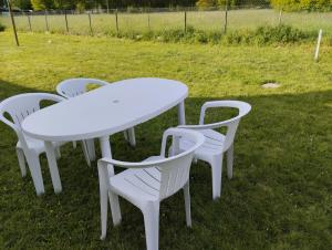a white table and four chairs in the grass at location pour 24h du mans in Arnage
