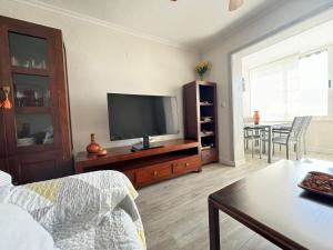 a living room with a television and a table at Natura playa By Sunset in La Venteta