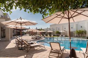 una piscina del complejo con sillas y sombrillas en Gran Hotel Mexico by Solaris, en Tehuacán