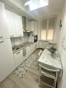 a white kitchen with a table and a sink at Casa Sole E Luna in Genova