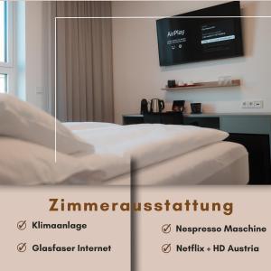a room with a bed and a tv on a wall at City Rooms Amstetten in Amstetten
