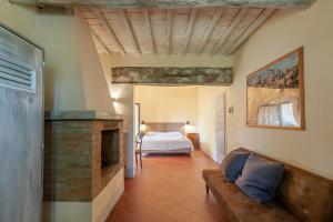 salon z łóżkiem i kominkiem w obiekcie Borgo Casa al Vento w mieście Gaiole in Chianti +37 zdjęć