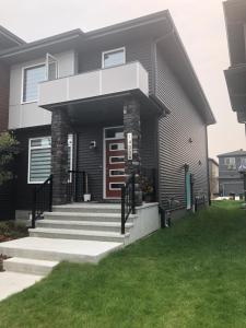 a black house with stairs and a porch at Cozy Haven! in Edmonton