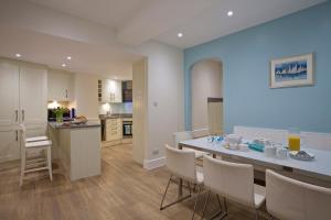 a kitchen and dining room with a table and chairs at 4 The Salcombe in Salcombe