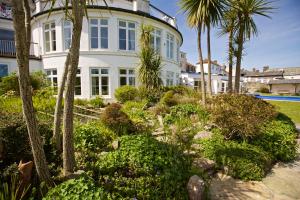a large white house with palm trees and a garden at 4 The Salcombe in Salcombe