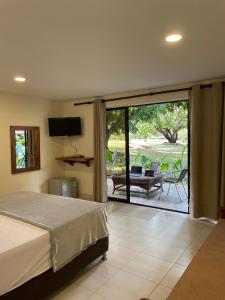 - une chambre avec un lit et une porte coulissante en verre dans l'établissement Casa Fuego, à La Pintada