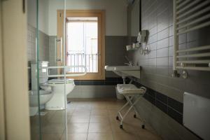 a bathroom with a toilet and a sink and a window at Guesthouse Villa Fabris in Thiene