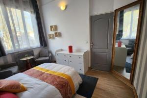 ein Schlafzimmer mit einem Bett und einem großen Spiegel in der Unterkunft Artiste in Douai
