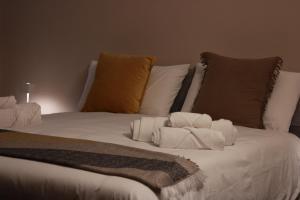 Una cama blanca con almohadas y toallas. en JOHN'S ROOMS, en Villa D'agri