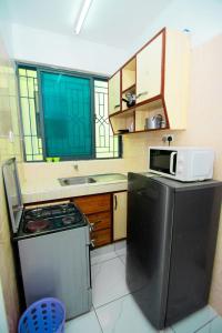 a small kitchen with a stove and a microwave at Mombasa bamburi staycation 2 in Mombasa