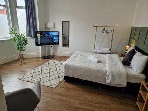 um quarto com uma cama e uma televisão de ecrã plano em West Beck House - Newcastle 3 em North Shields
