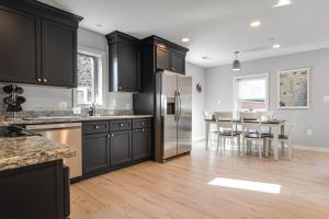 a kitchen with black cabinets and a stainless steel refrigerator at Waterfront Historical District Home Near River in North East