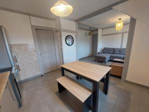 - un salon avec une table en bois et un canapé dans l'établissement Appart proche gare et centre ville, à Vierzon