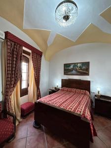 Un dormitorio con una cama grande y una lámpara de araña. en Casa Rural Tita Sacramento, en Hornachos