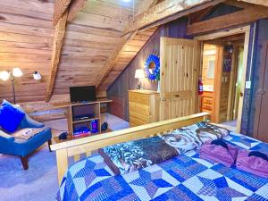 ein Schlafzimmer in einem Blockhaus mit einem Bett und einem Schreibtisch in der Unterkunft New Song in Sevierville